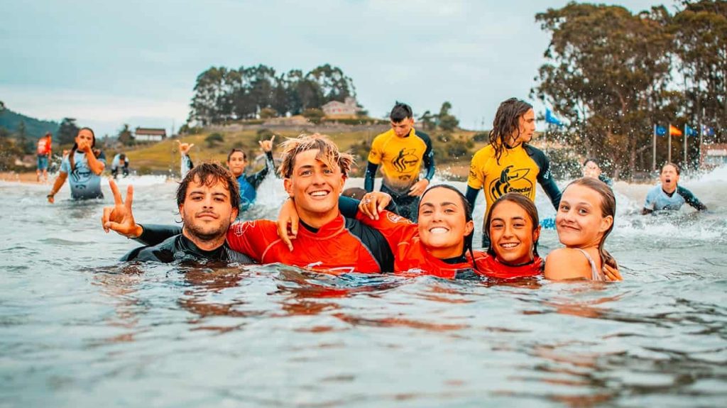 Niños disfrutando en el agua en el campamento de surf en Asturias
